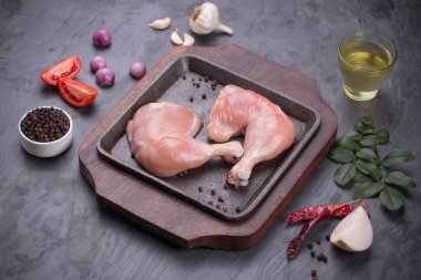 Gri desenli arka planı olan cızırtılı bir cızırtıda dizilmiş taze derisiz tavuk bacakları.. 