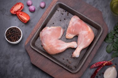 Gri desenli arka planı olan cızırtılı bir cızırtıda dizilmiş taze derisiz tavuk bacakları.. 