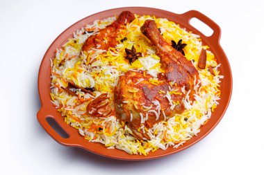 Mandi Tavuk Biryani, Hint tavuk biryani basmathi pilavı ve baharatlarla süslenmiş beyaz arkaplan ve desenli bir toprak eşyasıyla seçici bir odak noktası.