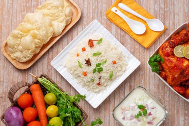 Sebze Pulav ya da Pulao 'nun yanında kızarmış tavuk, raita ve paapad ve bir sepet dolusu taze sebze.