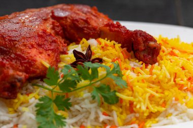 Siyah arkaplan ya da desenli meze olarak tavuk biryani ya da basmathi pilavlı Tandır tavuğu ve raita ya da raitha, seçici odak noktası.