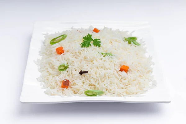 Veg Pulav or Pulao, made using basmathi rice ,vegetables and indian spices. arranged in a square white tableware with white colour background or texture