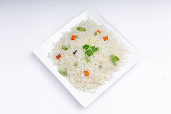 Veg Pulav or Pulao, made using basmathi rice ,vegetables and indian spices. arranged in a square white tableware with white colour background or texture