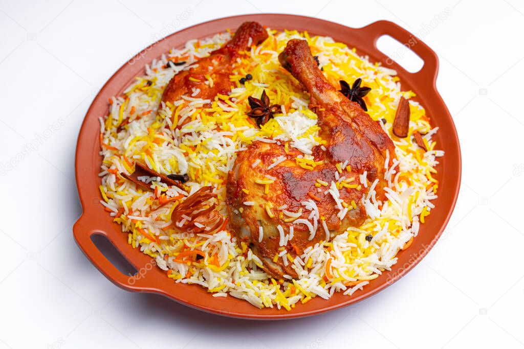 Mandi Chicken biryani ,Indian chicken biryani using basmathi rice and garnished with spices arranged in a earthenware with white  background or texture,selective focus