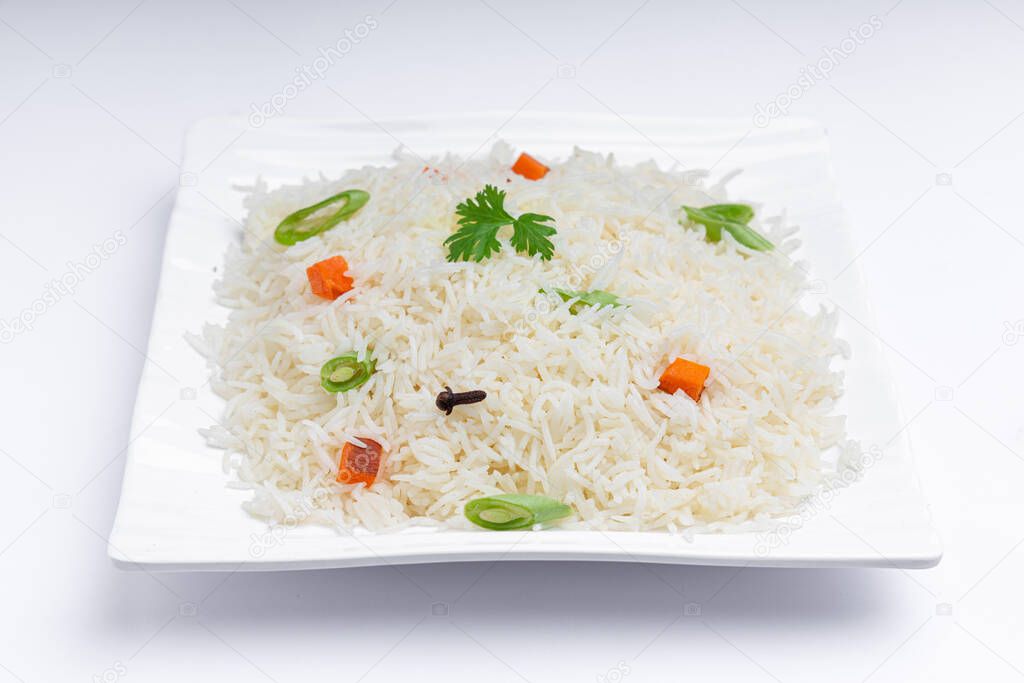 Veg Pulav or Pulao, made using basmathi rice ,vegetables and indian spices. arranged in a square white tableware with white colour background or texture