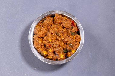 Sığır rostosu ya da pothu ulareyadu, akapper kaplamalı ve gri arkaplanda hindistan cevizi parçalarıyla süslenmiş kerala özel yemeği..