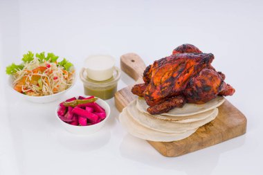 Shawai tavuğu, beyaz arka planda kubular ve mezeler olan ahşap bir üste dizilmiş..