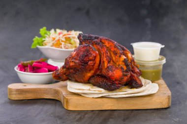 Shawai tavuğu, kubular ve gri arka planda mezeler olan ahşap bir üste ayarlandı..