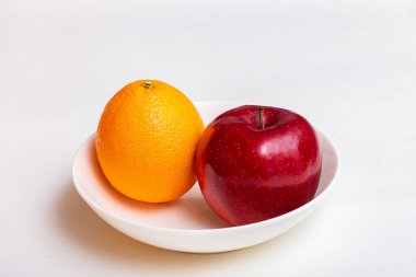 Beyaz bir kasede elma ve portakal