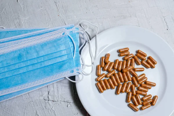 Solunum maskesi, mavi zemin üzerinde el ve tablet antibakteriyel kullanımı.