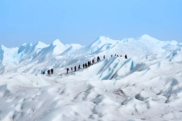Bir grup insan, Patagonya 'daki Perito Moreno buzulunun tepesine çıkmak için sıraya girdiler.