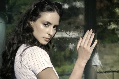 Genç siyah saçlı kadın şehirde yürüyor.