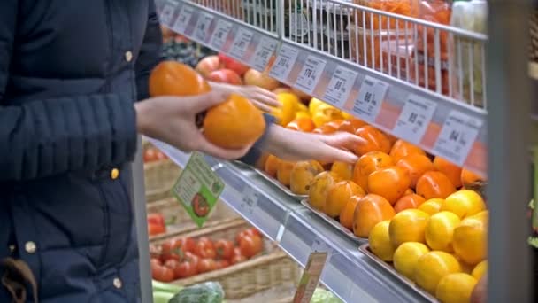 Young woman picks persimmon — Stock Video