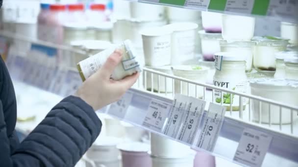 Moskou, Rusland - 21 februari 2016: Jonge vrouw kiest de yoghurt in de supermarkt — Stockvideo