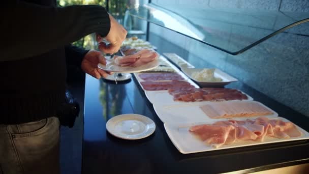 De man zet het vlees op een bord in de eetkamer — Stockvideo
