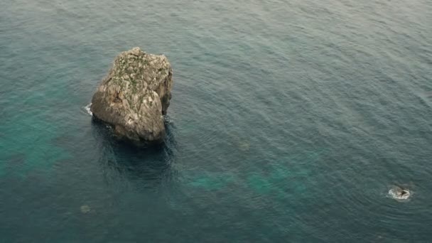 Rocher dans la mer, vue du haut des vagues et des falaises, eaux turquoise — Video