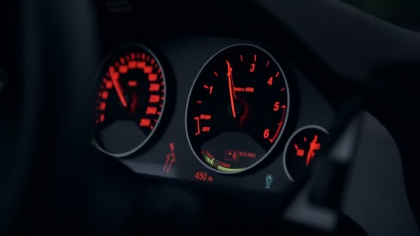 Hastighetsmätare och ratten i en bil med rött ljus — Stockvideo