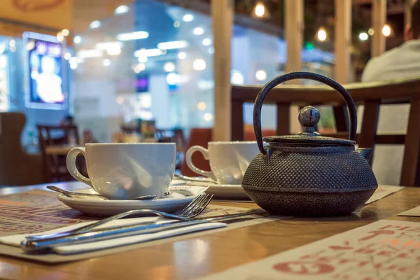 Mesa de café com chaleira de chá e copo branco — Fotografia de Stock