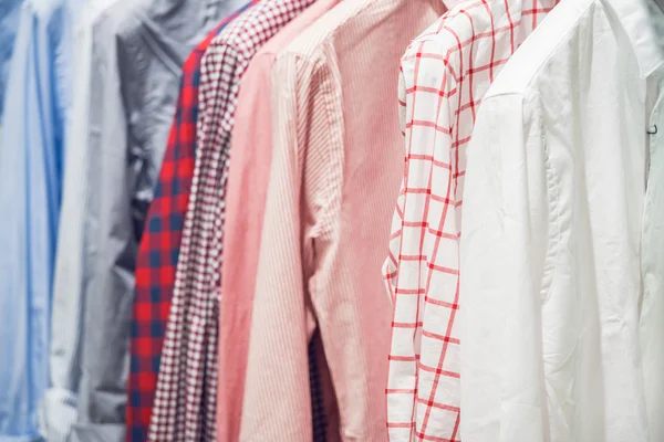 Sortimento de camisas masculinas clássicas penduradas no trilho — Fotografia de Stock