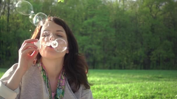 Cute Caucasian Girl Blowing Soap Bubbles In Park — Stock Video