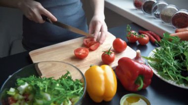 Genç kadın kesme sebze taze salata için mutfakta