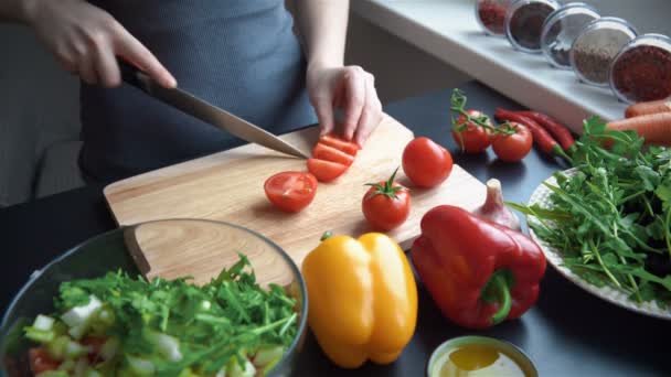 Ung kvinna skära grönsaker i köket för fräsch sallad — Stockvideo