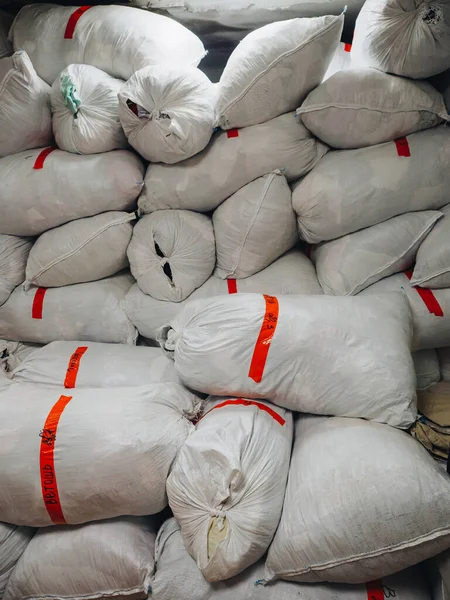Warehouse of bags with clothes shoes textile fabrics.