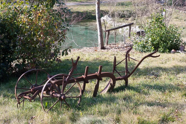 Gamla plogen i en trädgård — Stockfoto