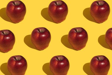 Sarı arka planda kırmızı elma deseni. Yaratıcı gıda konsepti.