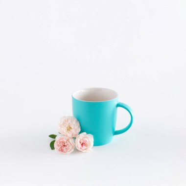 Beyaz arka planda gül çiçekleri olan kahve fincanı. Ofisin fotokopi alanı ile ilgili minimum yaratıcı kavramı. İş ve mola zamanı..