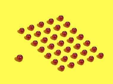 Sarı arka planda kırmızı elma deseni. Ardarda elmaların yaratıcı asgari konsepti. Tatlı yaz meyvesi.