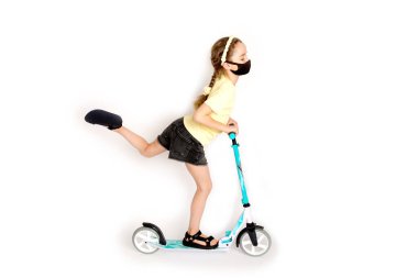 Koruyucu siyah Kovid-19 maskeli genç bir kız aktif olarak sporla ilgileniyor.