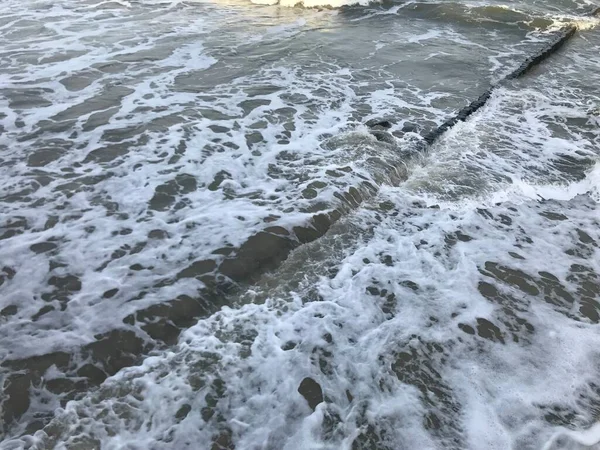 Briser les vagues sur un brise-lames en bois sur la côte de la mer Baltique. — Photo