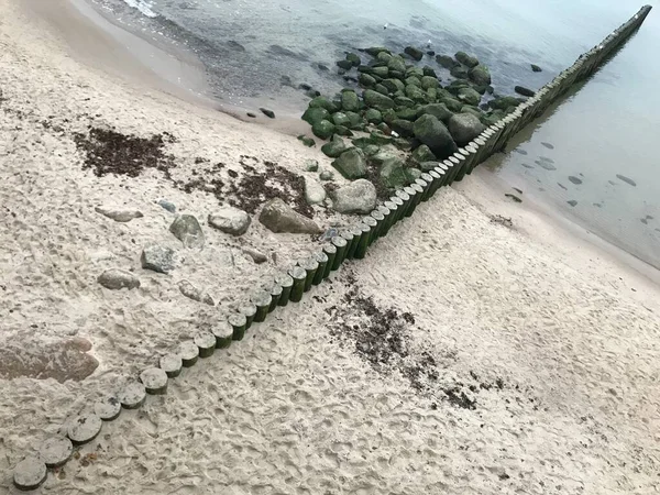バルト海沿岸の木の防波堤で波を破る. — ストック写真