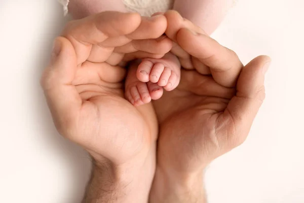 Pés de crianças em mãos de preensão de pai no branco. Pai e filho recém-nascido. Concepção de família feliz. — Fotografia de Stock