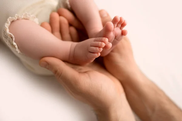 Los pies de los niños en las manos de la madre sobre blanco. Madre e hijo recién nacido. Concepto de familia feliz. — Foto de Stock