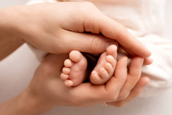 Un recién nacido se aferra a las mamás, papás dedo. Las manos de los padres y el bebé de cerca. Un niño confía y la sujeta fuerte — Foto de Stock