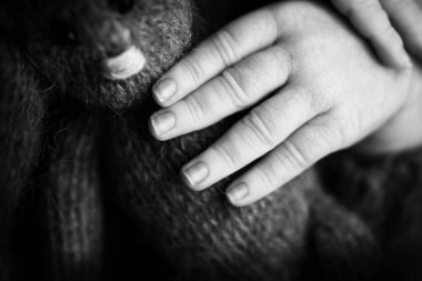 Childs 'ın eli, parmaklar kapalı. Yeni doğmuş bebek elleri, mutlu çocukluk konsepti, sağlık sigortası, tüp bebek, hijyen. Siyah beyaz fotoğraf.