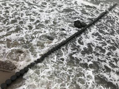 Baltık Denizi kıyısındaki ahşap bir dalgada dalgalar kırılıyor..