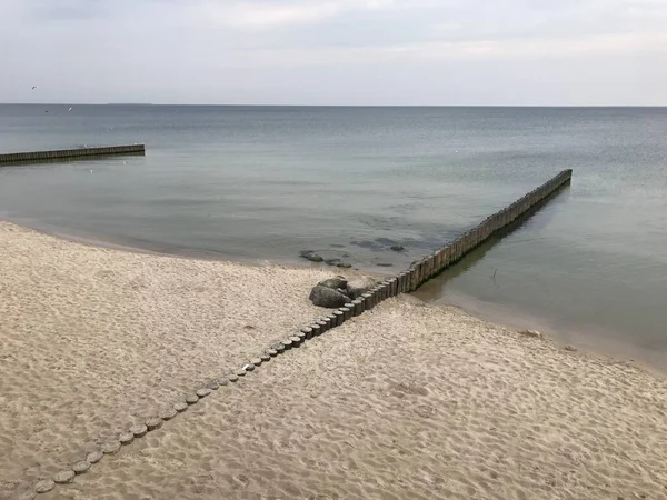 Briser les vagues sur un brise-lames en bois sur la côte de la mer Baltique. — Photo