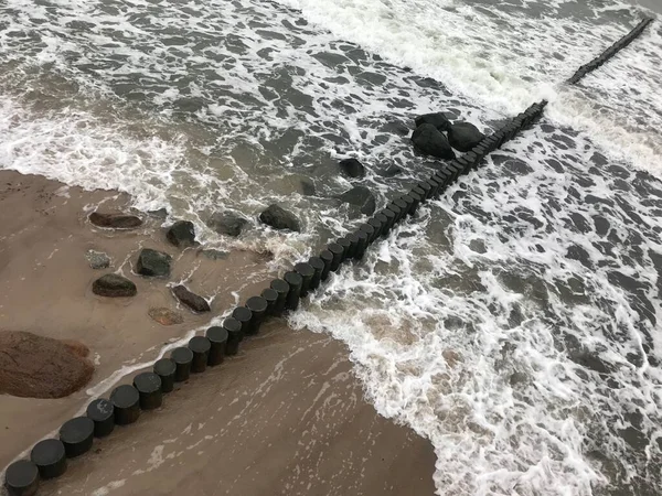 Briser les vagues sur un brise-lames en bois sur la côte de la mer Baltique. — Photo