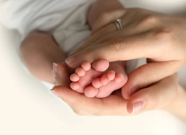 Χέρια γονέων. τα πόδια του νεογέννητου στα χέρια της μαμάς και του μπαμπά. Μωρά πόδια στα χέρια του. — Φωτογραφία Αρχείου