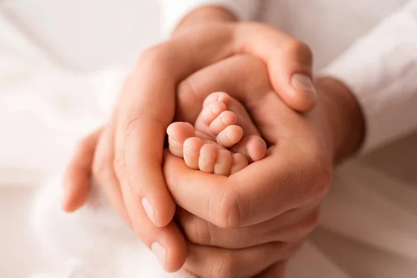 Manos de padres. Las piernas, los pies del recién nacido en manos de mamá y papá. — Foto de Stock