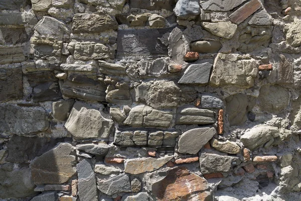 Wandstruktur aus alten rohen Ziegeln und Steinen. Alte Mauern, die von der Zeit zerstört wurden. Tiflis, Georgien. — Stockfoto