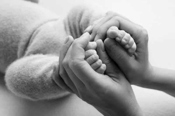 Fotografie s dětskými nohami, které se drží v dlaních mámy a táty. černobílá fotka. rodinné album. novorozenecké nohy. — Stock fotografie