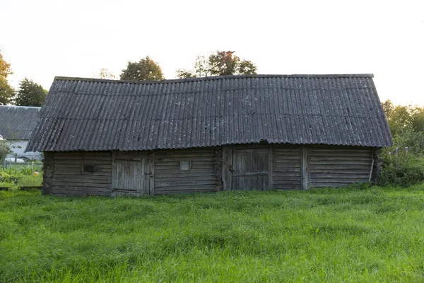 Eski ahşap terk edilmiş köy evi. Yaz, yeşil çimenler ve ağaçlar. — Stok fotoğraf