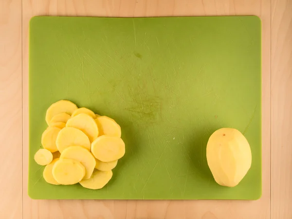 整个和切片土豆上绿色的塑料板 — 图库照片
