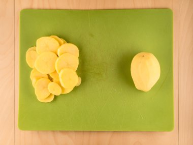 Yeşil kullanılan tahtada tüm ve dilimlenmiş patates
