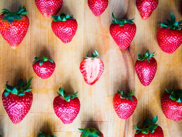 Een gesneden aardbei in een srranged patroon van aardbeien op — Stockfoto