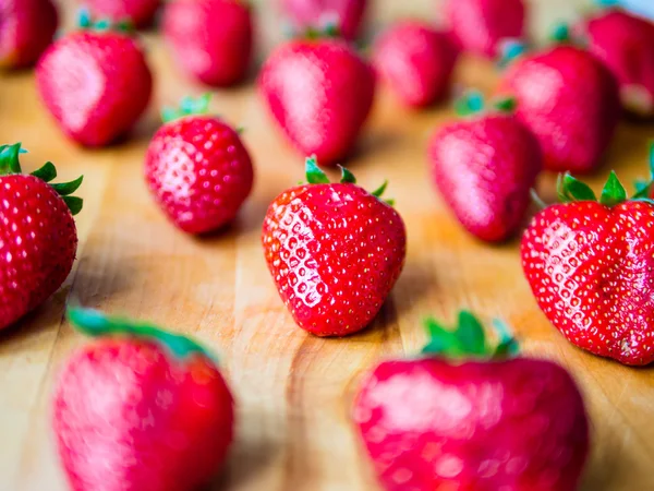 Gerangschikt aardbeien op een houten bord — Stockfoto